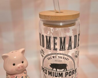 May include: A clear glass jar with a bamboo lid and a straw. The jar has a floral pattern and the text "HOMEMADE BBQ. RES. TAURANT EST. 2022 PREMIUM PORK Farm SLOGAN HERE" printed on it.