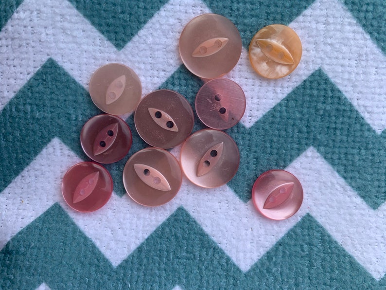 Collection of 10 pink fish eye buttons various shades and sizes.