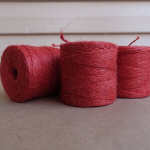 May include: Three spools of red twine, each wound tightly and ready for use.