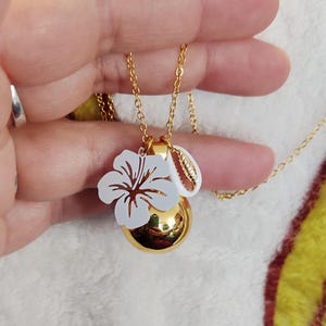 Bola ciążowa z białym hibiskusem i muszlą oraz złotą kulą