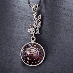 May include: A silver-toned pendant necklace featuring a howling wolf charm and a round pendant with a galaxy design. The necklace has a black cord and a decorative clasp. The round pendant has a silver frame.