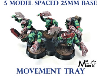 May include: Five green and red painted miniature figures on a black plastic movement tray. The tray is designed to hold 25mm bases and is spaced for five models. The tray is labeled "Movement Tray".