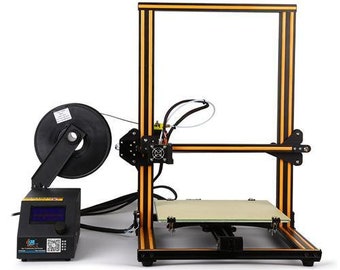 May include: A black and yellow 3D printer with a filament spool holder and a heated bed. The printer has a black frame with yellow accents and a black and white LCD screen.