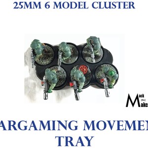 May include: Six 25mm model figures are arranged on a black plastic movement tray. The tray has six circular slots for the figures to stand in. The figures are painted in green and brown camouflage colors. The tray is labeled "Wargaming Movement Tray" and "25MM 6 MODEL CLUSTER".
