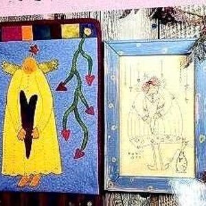 May include: Two framed pieces of art. The first piece features a yellow figure with a large heart in the center, surrounded by red hearts and green vines. The second piece features a blue figure with a red heart in the center, surrounded by white and blue lines.