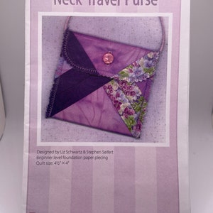 May include: A purple and floral fabric neck travel purse with a button closure. The pattern is for a beginner level foundation paper piecing project. The finished quilt size is 4 1/2 inches by 4 inches. eQuiltPatterns.com