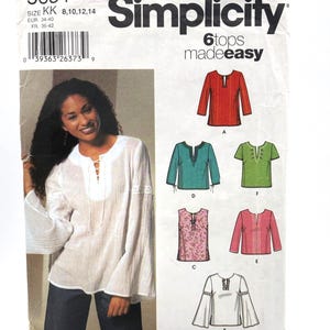 May include: A Simplicity 5684 sewing pattern envelope for six tops, labeled madeeasy. The front displays a white long-sleeve top with a lace-up neckline and lace trim on the sleeves. Illustrations show six variations of tops in red, teal, green, floral, pink, and white.