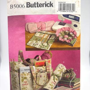 May include: A Butterick sewing pattern package, B5006, featuring images of sewing projects. The package displays a sewing machine, fabric accessories, and a tote bag with floral and plaid patterns. The text "SEWING" is visible on a label.