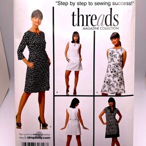 May include: Simplicity sewing pattern featuring various dress designs. The cover includes the text "threads MAGAZINE COLLECTION" and "Step by step to sewing success!" with size information.