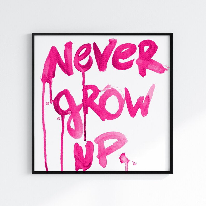 Puede incluir: Una pintura de acuarela rosa con las palabras "NEVER GROW UP". Las palabras est&aacute;n escritas en un estilo audaz y juguet&oacute;n con gotas de pintura que caen por la p&aacute;gina.