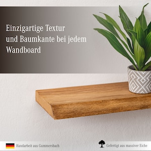 May include: A wooden shelf with a natural wood finish and a live edge. The shelf is mounted on a white wall and has a potted plant on top of it. The text "Einzigartige Textur und Baumkante bei jedem Wandboard" is visible in the image.