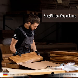 May include: A person carefully packages a wooden board in a cardboard box. The board is made of solid oak and has a natural wood finish. The text "Sorgf&auml;ltige Verpackung" is visible in the upper right corner of the image.