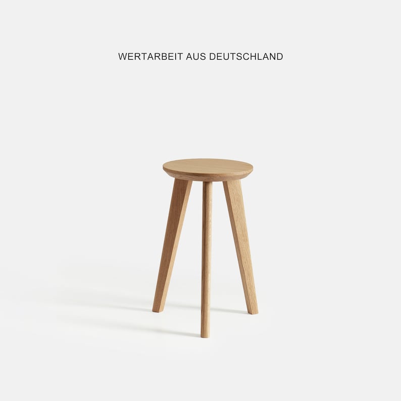 May include: A wooden stool with a round seat and three legs. The stool is made of natural wood and has a light brown color.