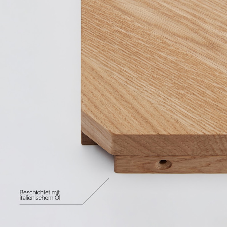 May include: A close-up of a wooden cutting board with a beveled edge. The board is made of light wood and has a natural finish. The text "Beschichtet mit italienischem &Ouml;l" is visible on the bottom of the image.