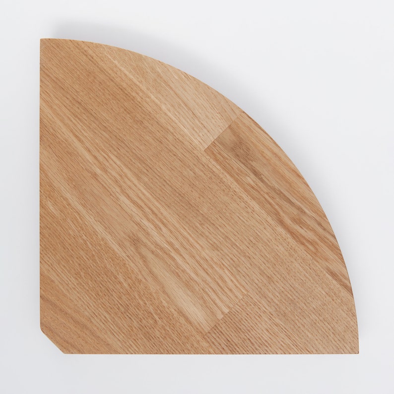 May include: A quarter-circle wooden shelf made of light brown oak.