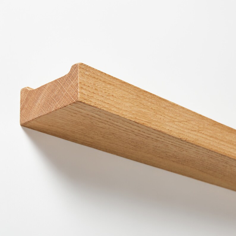 Puede incluir: Una estanter&iacute;a de madera natural con un borde curvo. La estanter&iacute;a est&aacute; hecha de madera maciza y tiene un acabado marr&oacute;n claro.