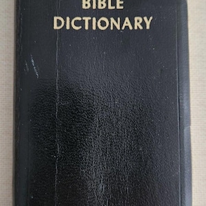 May include: A black leather-bound book with the title "BIBLE DICTIONARY" embossed in gold lettering.
