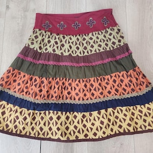 May include: A set of three ceramic mugs with a speckled, matte finish. The mugs are in shades of cream, light brown, and dark brown. Each mug has a simple, minimalist design and a rounded handle.