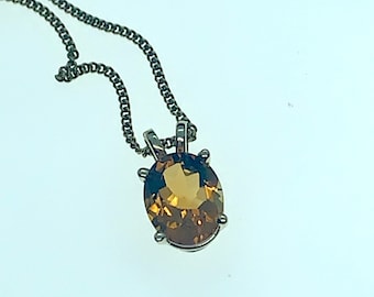 May include: A silver chain necklace with a brown oval gemstone pendant.