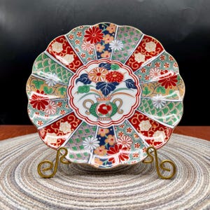 May include: A set of three ceramic mugs with a speckled, matte finish. The mugs are in shades of cream, light gray, and dark gray. Each mug has a simple, minimalist design and a rounded handle.