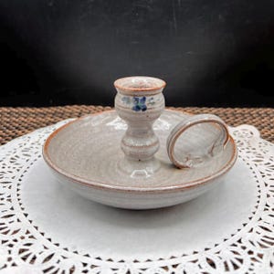 May include: A set of three ceramic mugs with a speckled, matte finish. The mugs are in shades of cream, light gray, and dark gray. Each mug has a simple, minimalist design and a rounded handle.