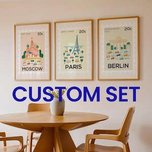 May include: Three framed travel-themed art prints featuring iconic landmarks: Saint Basil's Cathedral in Moscow, the Eiffel Tower in Paris, and the Brandenburg Gate in Berlin. Each print has a postage stamp design with a vintage aesthetic. The text "CUSTOM SET" is displayed.