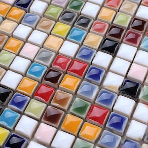 May include: A close-up of a colourful mosaic tile sheet. The tiles are small, square, and arranged in a staggered pattern. The colours include red, blue, green, yellow, white, and brown.