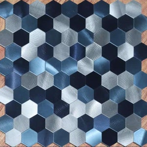 May include: A sheet of metallic hexagonal tiles in shades of blue and silver. The tiles have a brushed finish and create a modern, geometric pattern.