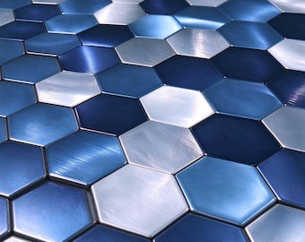 Puede incluir: Una colección de azulejos hexagonales dispuestos en un patrón repetitivo. Los azulejos presentan un acabado metálico en varios tonos de azul marino profundo, azul real brillante y plata fría, creando una apariencia de superficie reflectante.