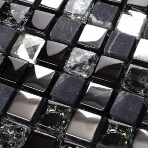 May include: Black, silver, and clear glass mosaic tiles. The tiles are arranged in a random pattern.