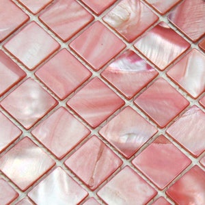 Puede incluir: Azulejos de mosaico iridiscentes de color rosa con forma cuadrada. Los azulejos están hechos de nácar y tienen un brillo sutil.