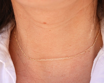 May include: A delicate gold chain necklace with a simple, classic design.