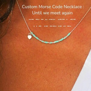 Peut inclure: Un collier en argent avec un pendentif en forme de cœur et des perles turquoise. Le collier présente un motif en code Morse et le texte "Custom Morse Code Necklace: Until we meet again."