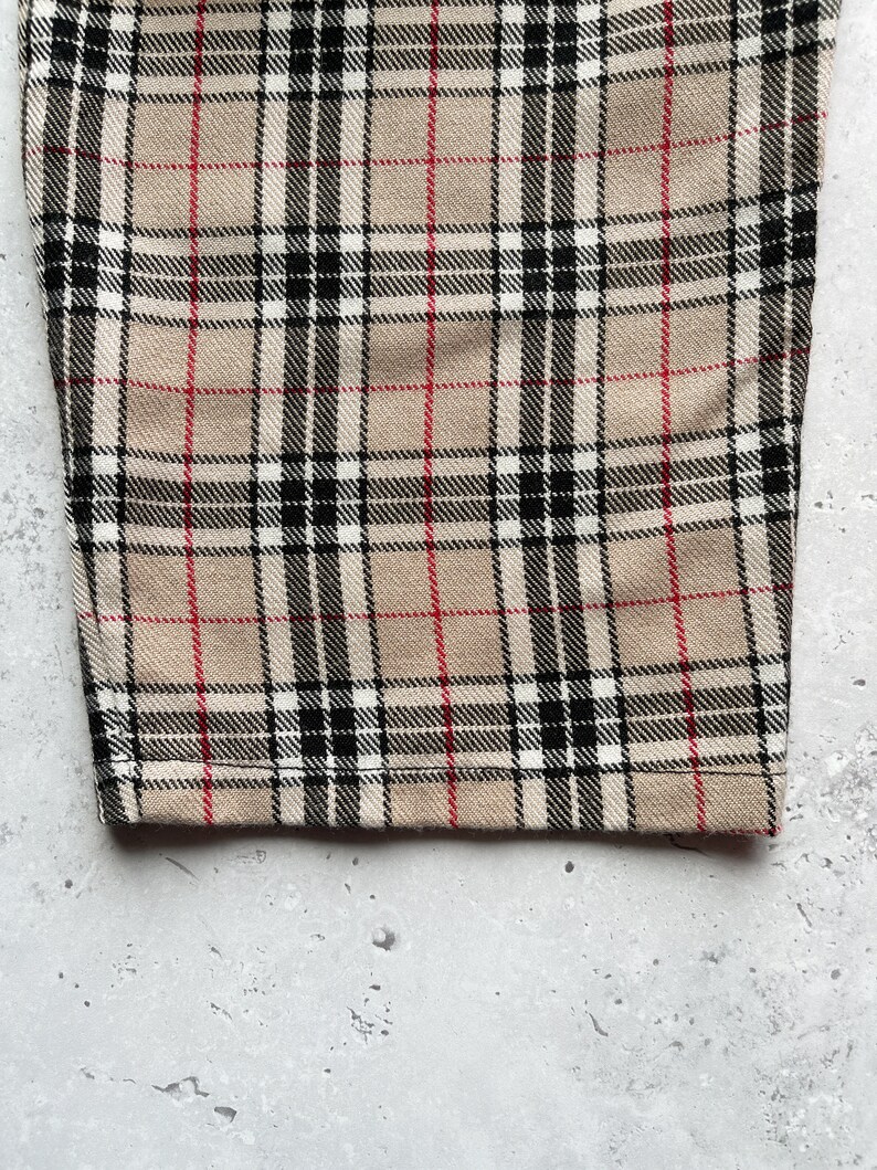 Beige nova check tartan tapered leg trousers close up