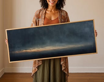 May include: A rectangular landscape painting in a light wood frame featuring a dark, moody sky with deep blue and charcoal tones transitioning into a soft, glowing horizon line of muted orange and gold light across the center of the canvas.
