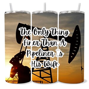 Op de afbeelding: Een set van drie roestvrijstalen bekers met een zonsondergangachtergrond en een silhouet van een olieplatform. De tekst op de bekers luidt "Het enige dat mooier is dan een  pijpleider is zijn vrouw."