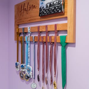 Gepersonaliseerde medaille- en slabbetjehouder gemaakt van kersenhout, tentoongesteld in de thuisgymnastiek, ter ere van hardloopprestaties