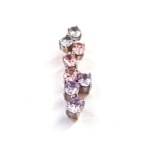 May include: A silver pendant with a gradient of light blue, pink, and purple gemstones.