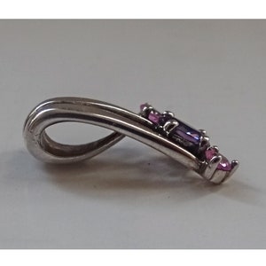 Pode incluir: Pingente de prata com um design de pedras preciosas roxas e cor-de-rosa. O pingente tem um la&ccedil;o na parte superior para prender a uma corrente.
