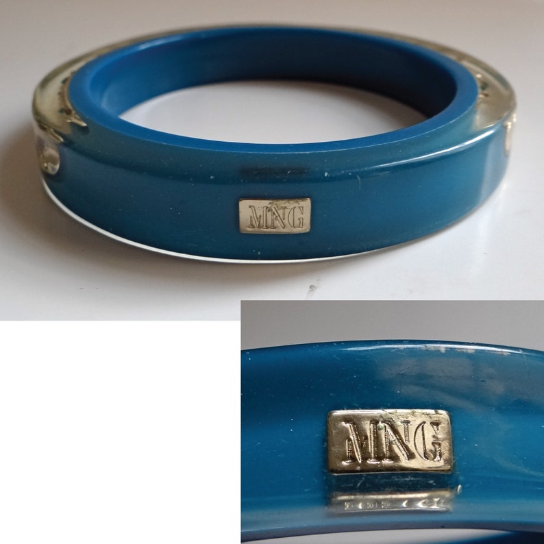 Pu&ograve; includere: Un braccialetto rigido blu turchese con un accento in metallo argentato e la parola "MNG" incisa sul davanti.
