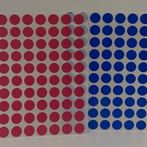 May include: Two sheets of stickers with a grid of red and blue circles.