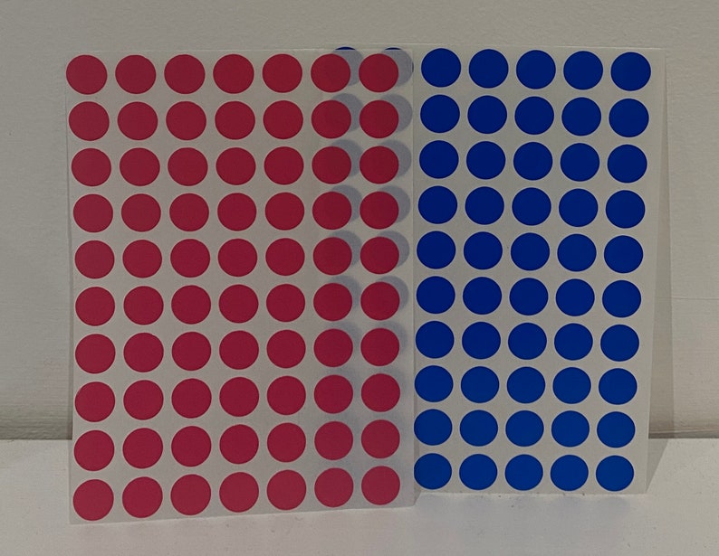 May include: Two sheets of stickers with a grid of red and blue circles.
