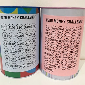 May include: Two metal money challenge jars with colorful designs. The jar on the left has a &pound;300 money challenge label and the jar on the right has a &pound;500 money challenge label. Both jars have a grid of circles with different amounts of money printed on them.