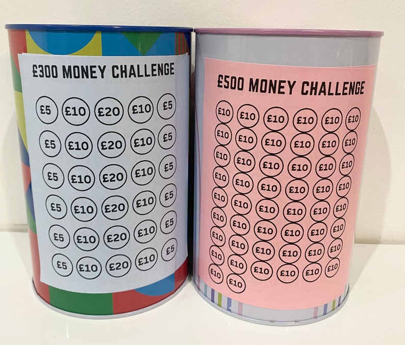 May include: Two metal money challenge jars with colorful designs. The jar on the left has a &pound;300 money challenge label and the jar on the right has a &pound;500 money challenge label. Both jars have a grid of circles with different amounts of money printed on them.