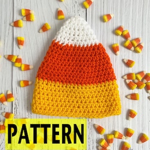 Può includere: Un cappello all'uncinetto a forma di caramella di mais bianca, arancione e gialla, circondato da caramelle di mais. La parola "PATTERN" è visualizzata in un riquadro giallo. Perfetto per Halloween o eventi a tema.
