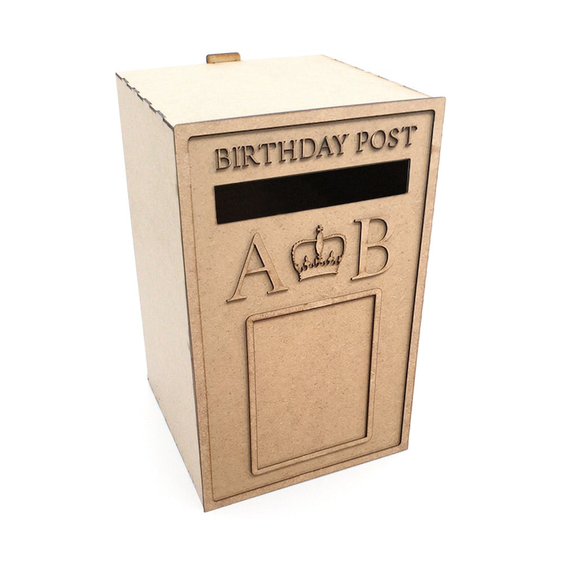 May include: A light brown wooden birthday post box with the words "BIRTHDAY POST" above a slot. The letters "A" and "B" flank a crown, and a rectangular frame is below. The box is on a white background.