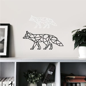 May include: A wall decal set featuring two geometric fox silhouettes. One fox is rendered in solid black lines, while the other is rendered in solid white lines. Both foxes are depicted in a walking profile pose with a triangular polygon design.