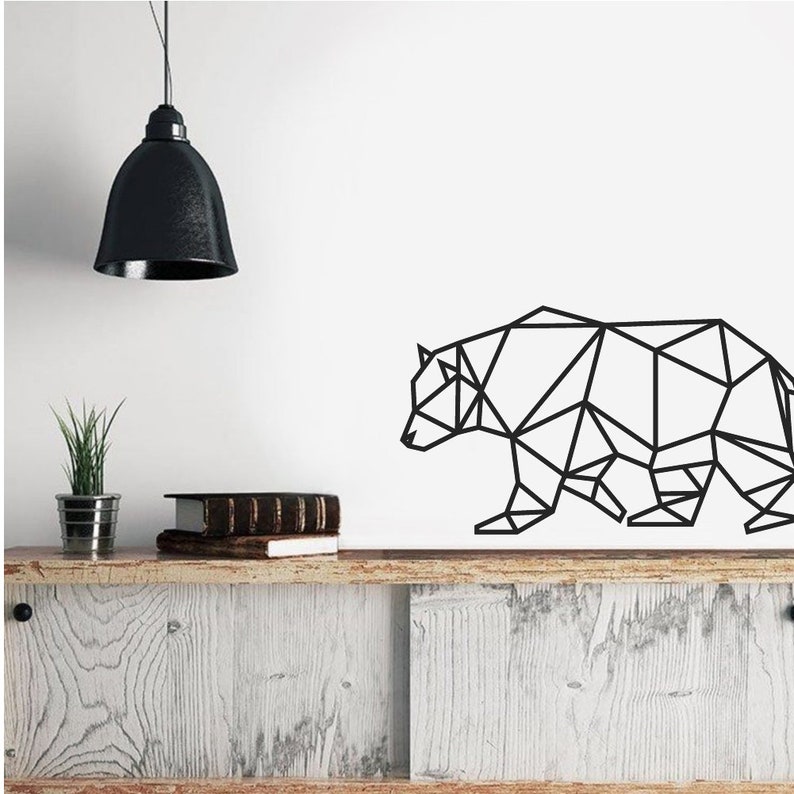 May include: A black geometric wall decal depicting the silhouette of a bear. The design is composed of interconnected straight lines and triangles, creating a stylized, angular representation of the animal in a walking profile position.
