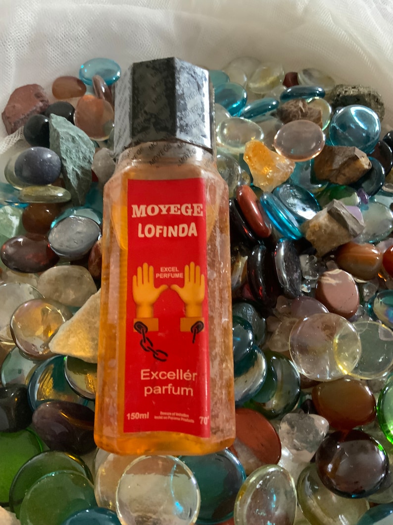 Pu&ograve; includere: Una bottiglia di vetro trasparente con un'etichetta rossa che dice "Moy&egrave;ge Lofinda Excell&eacute;r parfum" e "Excel Perfume". La bottiglia ha una capacit&agrave; di 150 ml e ha un tappo nero. L'etichetta presenta anche un'immagine di cartoni animati di due mani con catene.