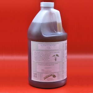 May include: A gallon jug of Super Compost Tea, a natural compost product for revitalizing potted and outdoor plants. The label features the product name, ingredients, and a QR code. The jug is brown and has a white cap.